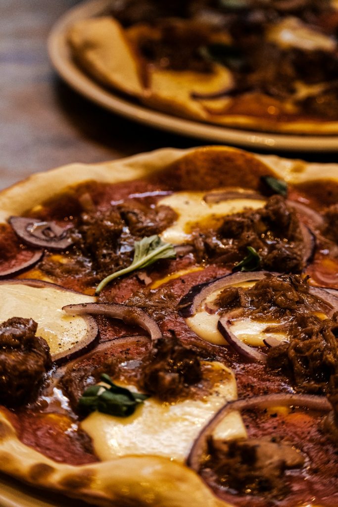 a-close-up-of-two-pizzas-on-a-table-ywl4d-qdtu8